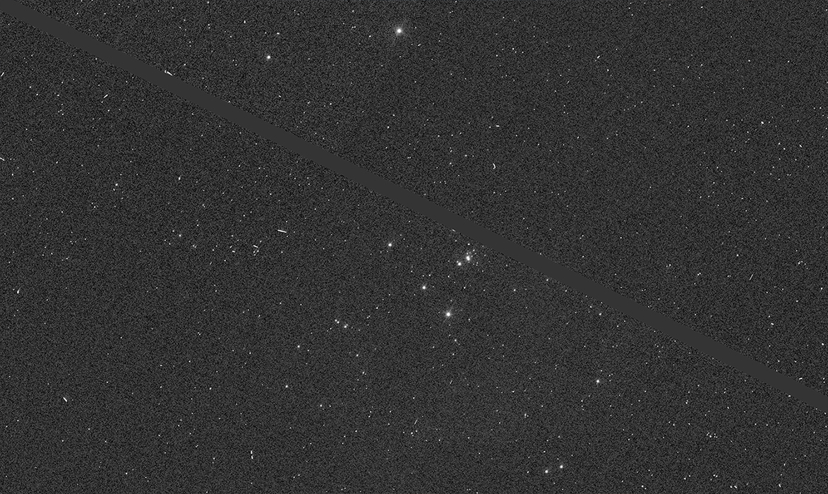 A faint star field with a dark, diagonal line through it